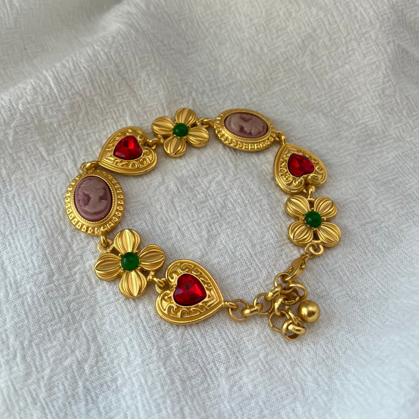 Pulsera vintage dorada con piedras preciosas y corazón de flores