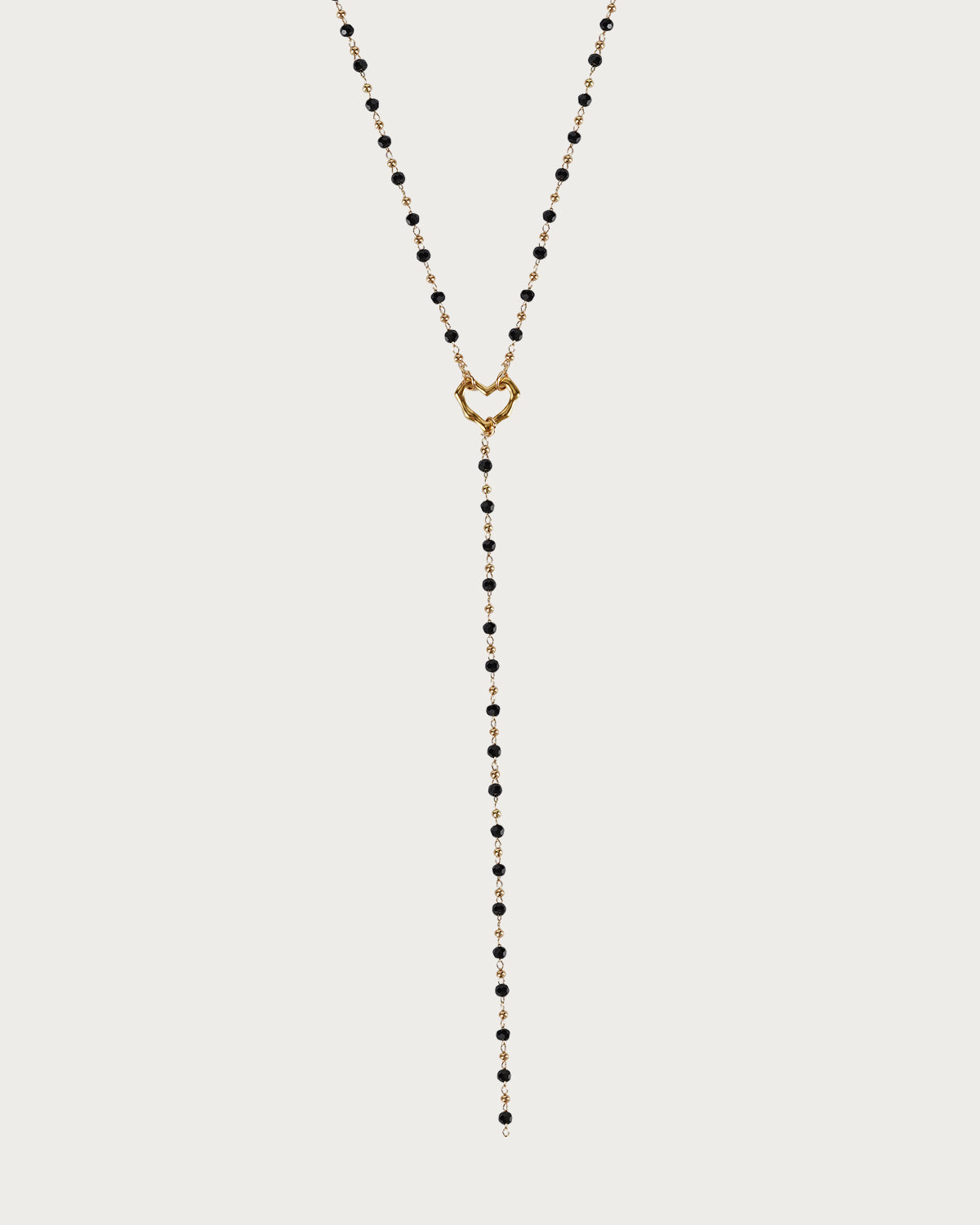 Collar de lazo dorado con corazón de cuentas negras