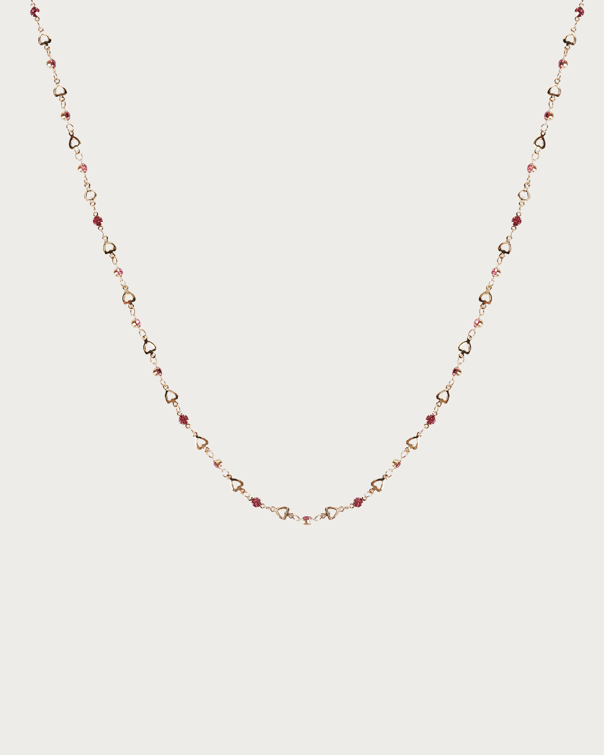 Collar de lazo dorado con corazón pequeño en rosa