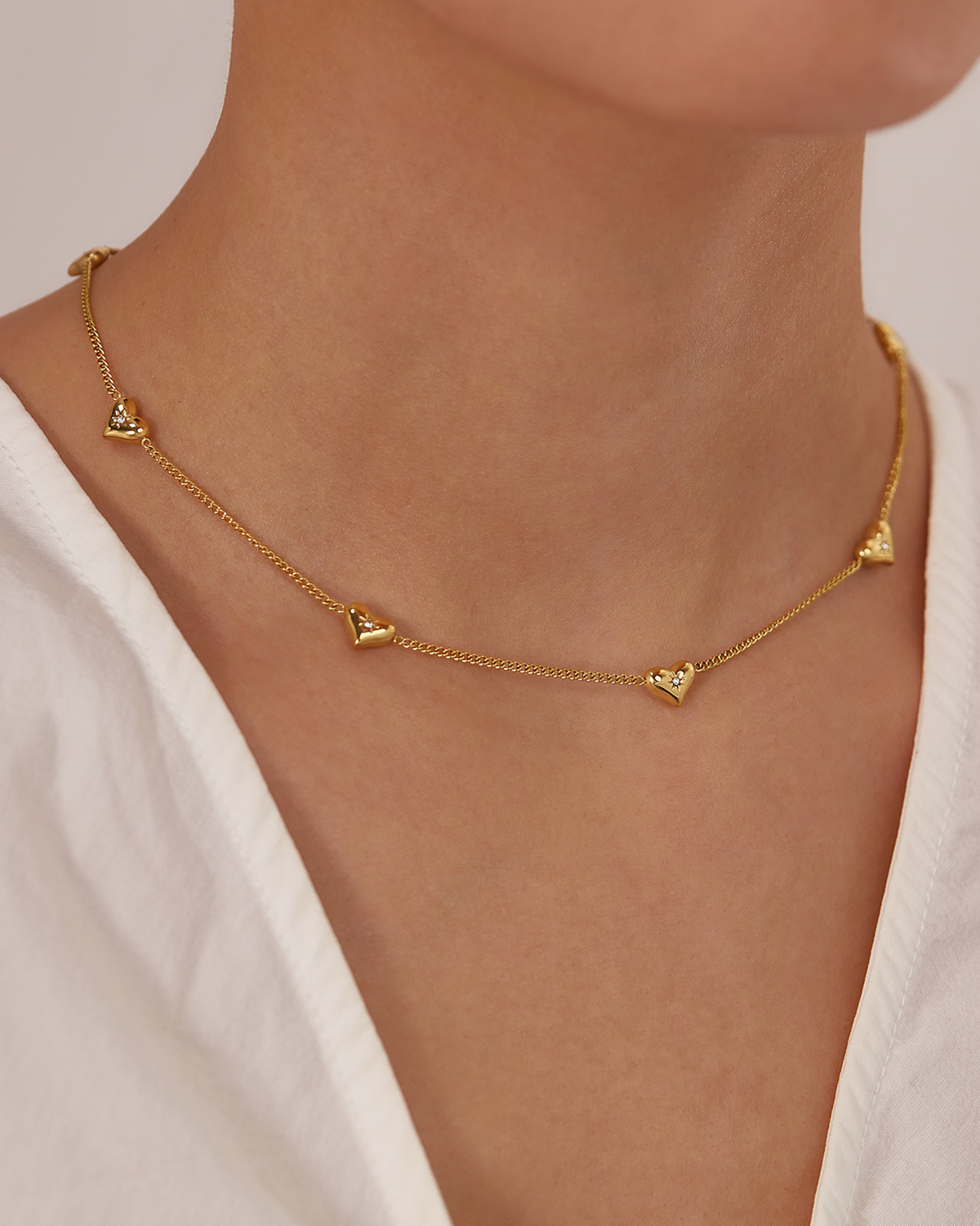 Collar dorado con pequeños corazones brillantes