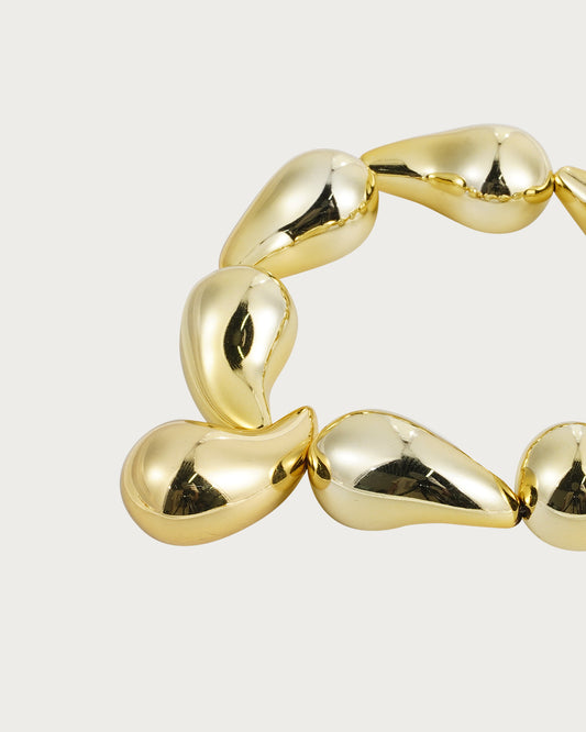 Pulsera elástica dorada con gotas de agua