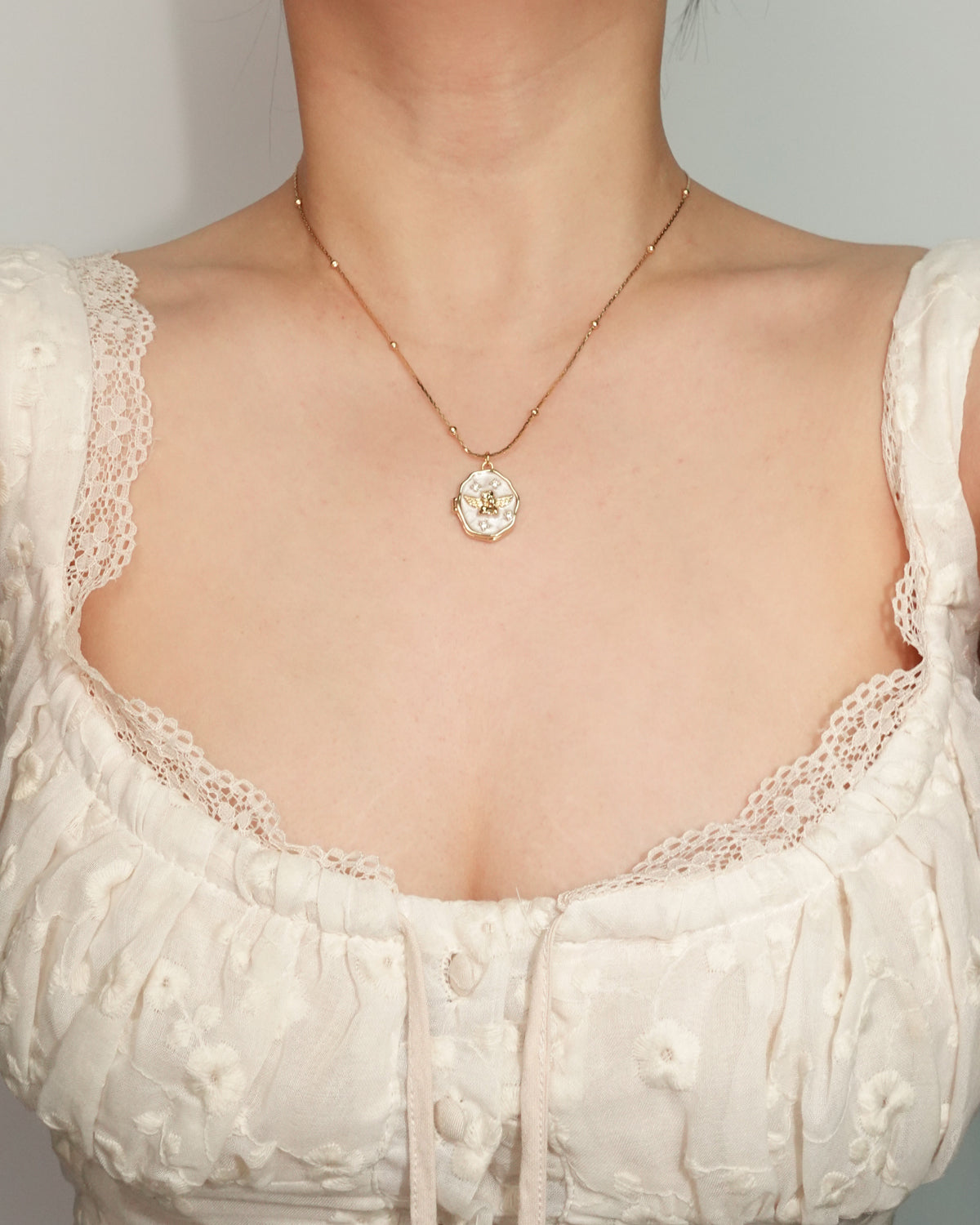 Collar con colgante dorado de medallón de concha angular de esmalte