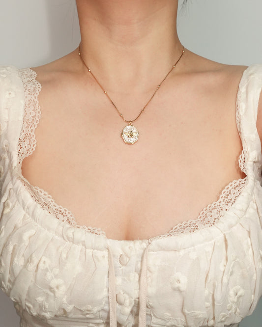 Collar con colgante dorado de medallón de concha angular de esmalte
