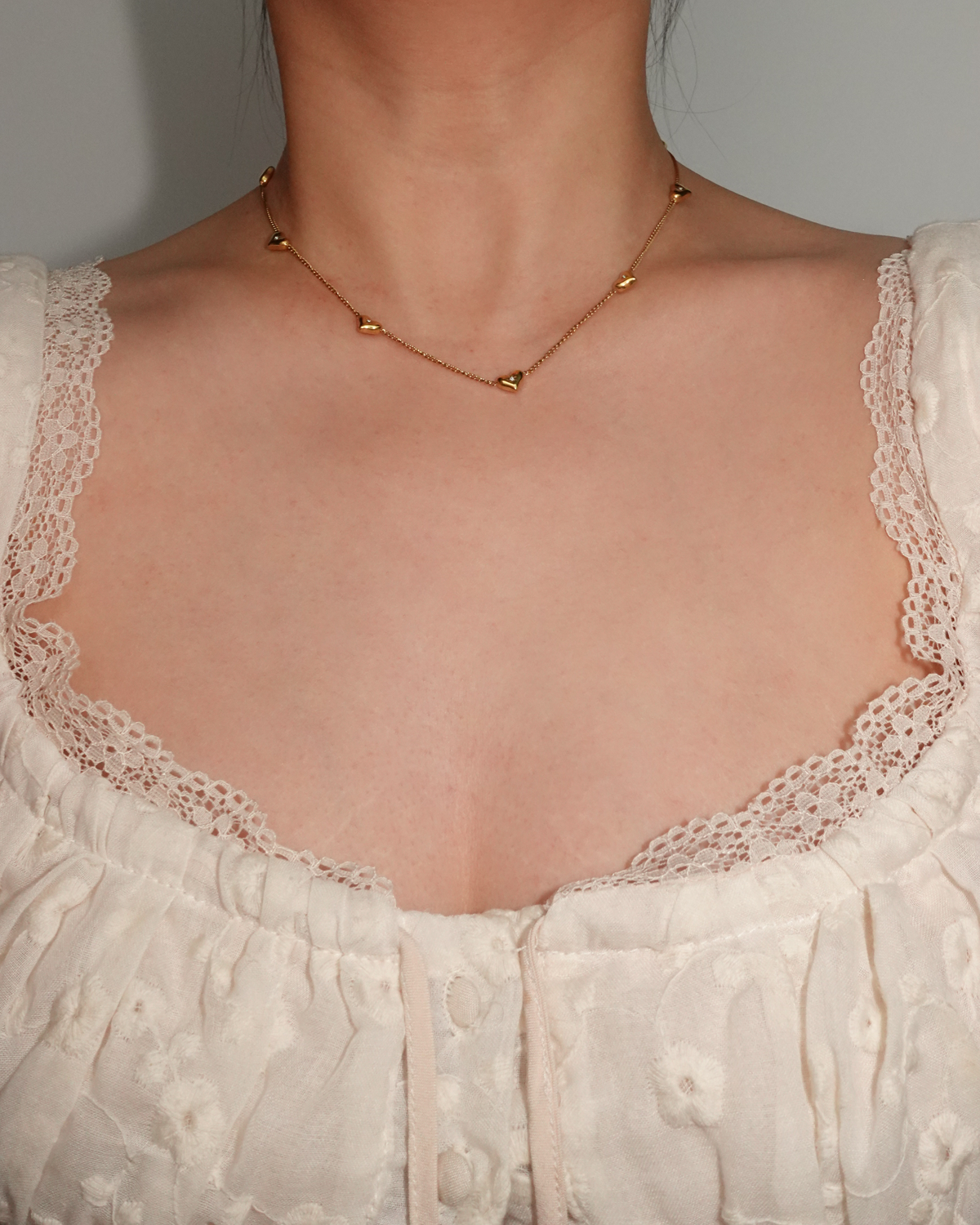 Collar dorado con pequeños corazones brillantes