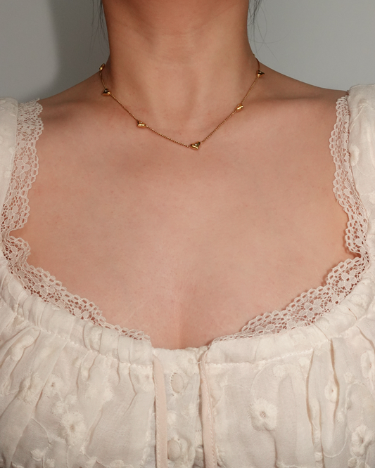 Collar dorado con pequeños corazones brillantes