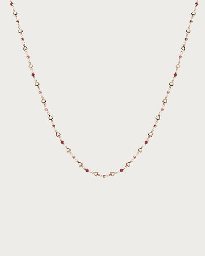 Collar de lazo dorado con corazón pequeño en rosa